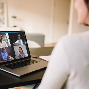 Woman using VOIP on her computer while looking at people she is talking to